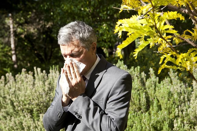 man-blowing-his-nose-outdoors-because-of-pollen-allergy